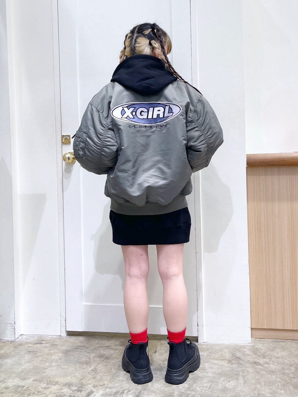 グリーン系のMA-1、ブラック系のパーカー、ブラック系のショルダーバッグを着用したレディースの冬コーディネートの2枚目の写真