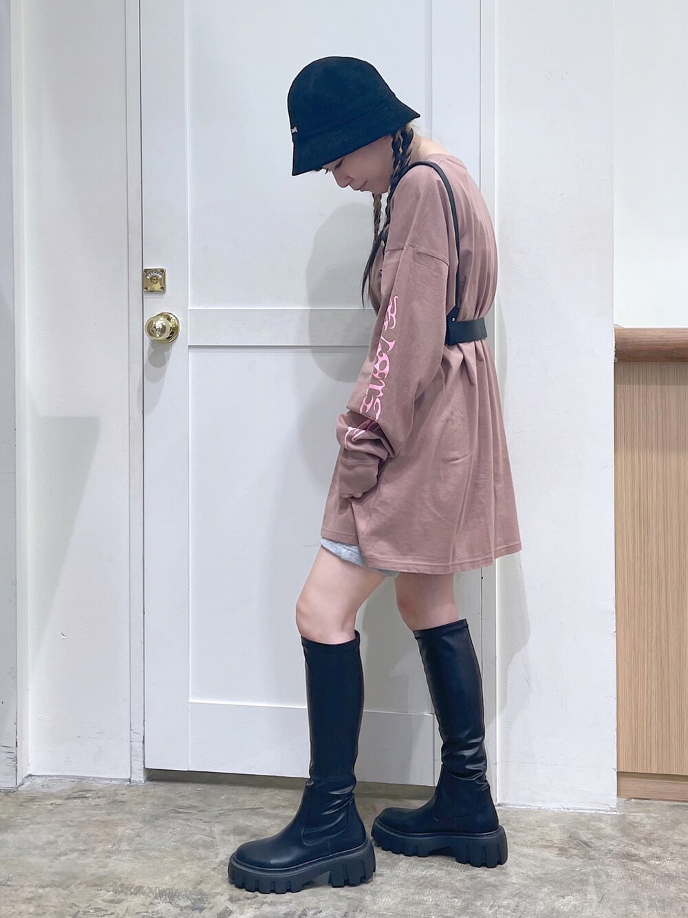 ブラウン系のワンピース、グレー系のスウェットパンツ、ブラック系のブーツを着用したレディースの秋コーディネートの3枚目の写真