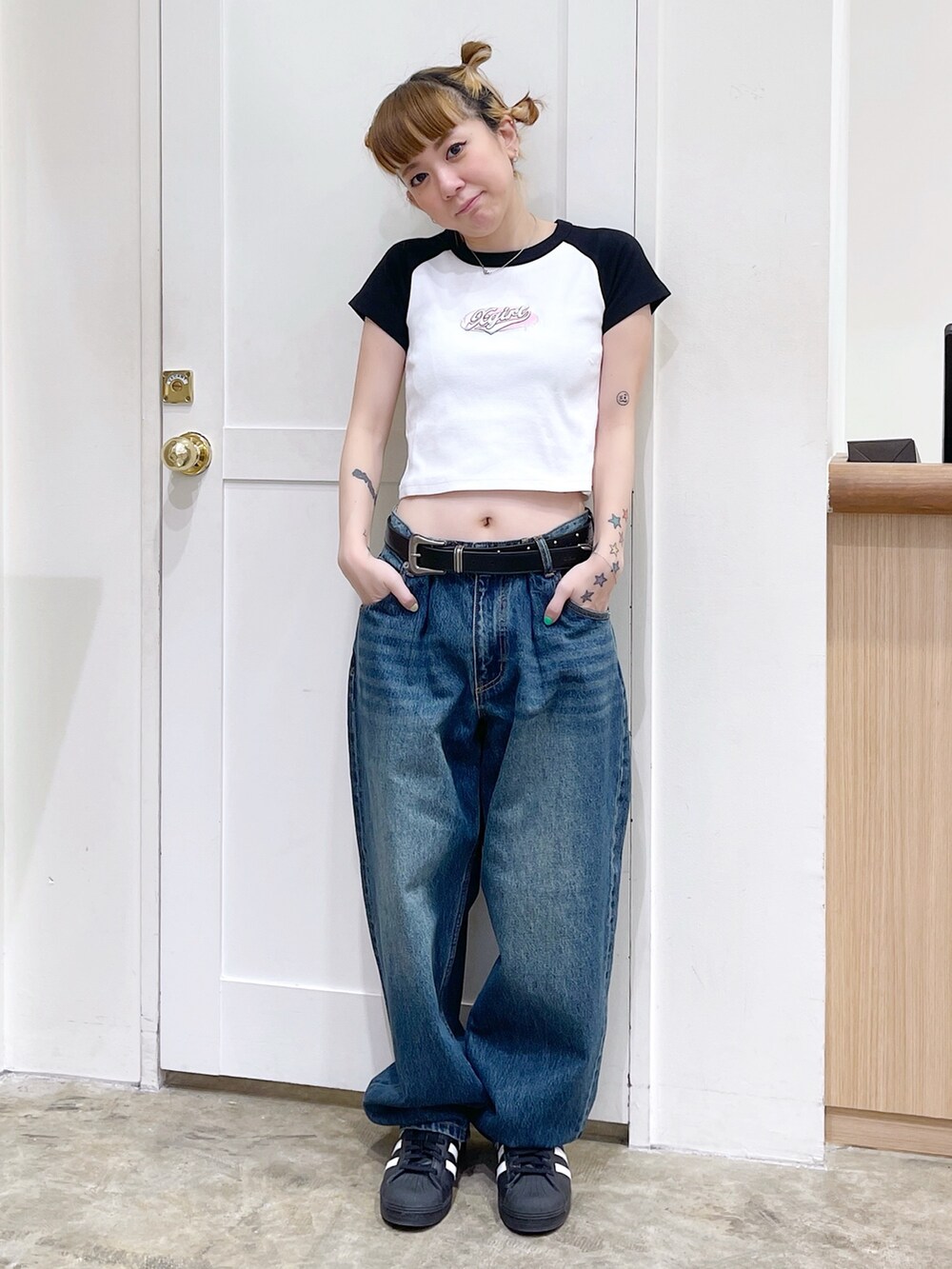 ブラック系のパーカー、ホワイト系のTシャツ/カットソー、ブルー系のデニムパンツを着用したレディースの春コーディネートの5枚目の写真