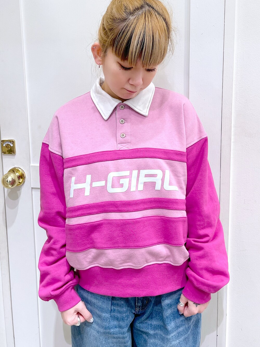 ピンク系のスウェット、ブルー系のデニムパンツ、ホワイト系のトートバッグを着用したレディースの冬コーディネートの2枚目の写真