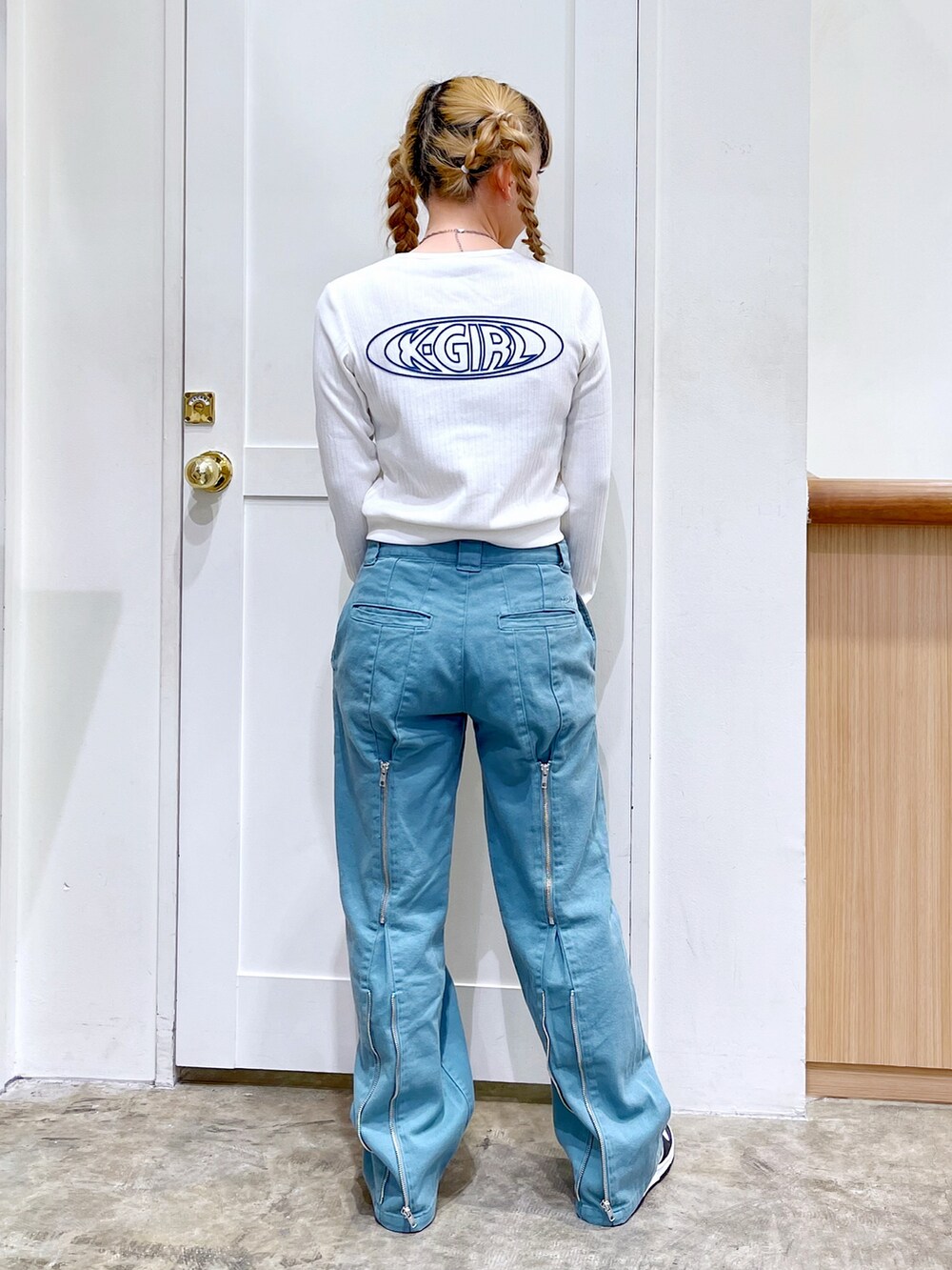 ホワイト系のカーディガン/ボレロ、ブラック系のトートバッグ、グリーン系のデニムパンツを着用したレディースの春コーディネートの5枚目の写真