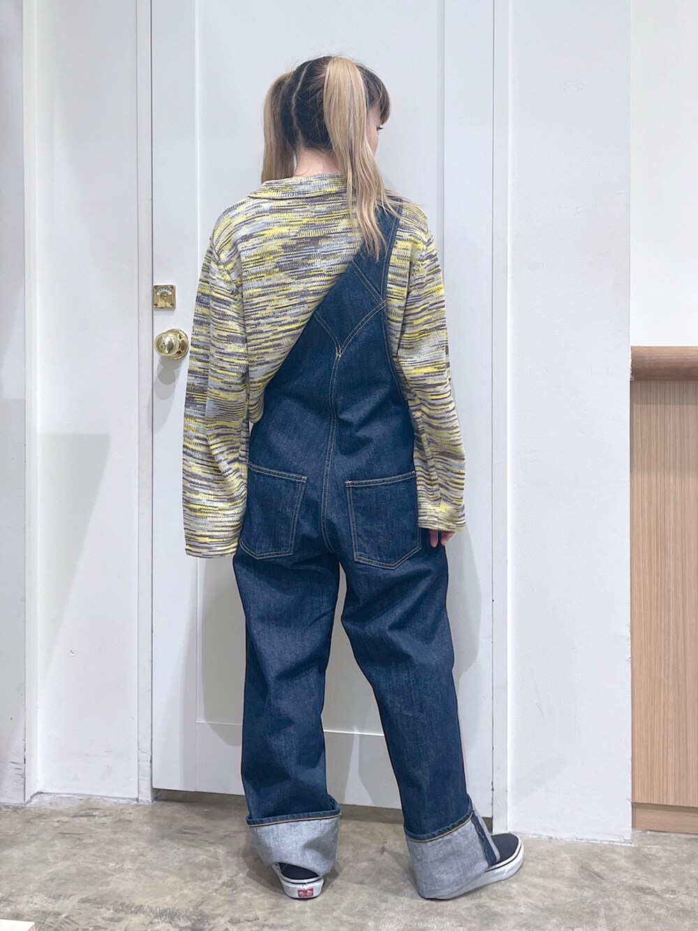 ブルー系のサロペット/オーバーオール、イエロー系のニット/セーター、ブラック系のストール/ショールを着用したレディースの秋コーディネートの4枚目の写真