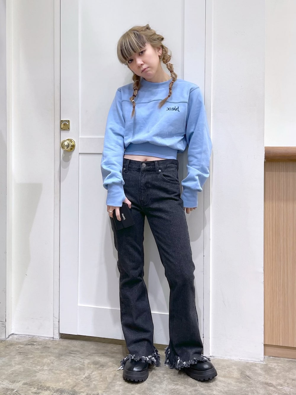 ブルー系のスウェット、ブラック系のデニムパンツ、ブラック系の財布を着用したレディースの冬コーディネートの3枚目の写真