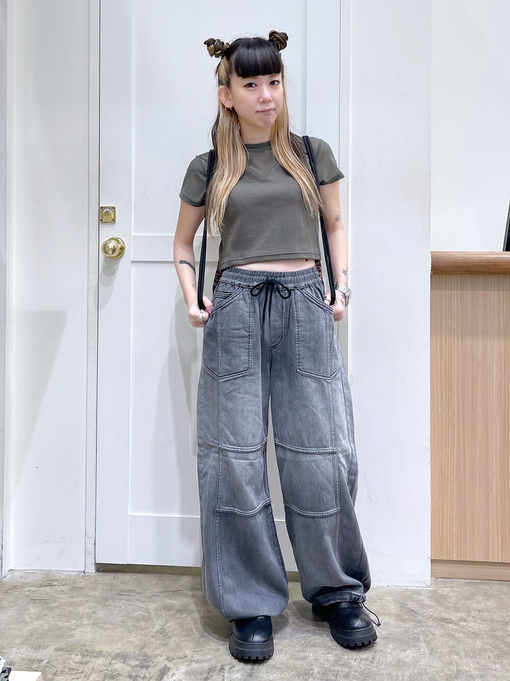 グリーン系のTシャツ/カットソー、ブラック系のデニムパンツ、ブラウン系のバックパック/リュックを着用したレディースの夏コーディネートの2枚目の写真