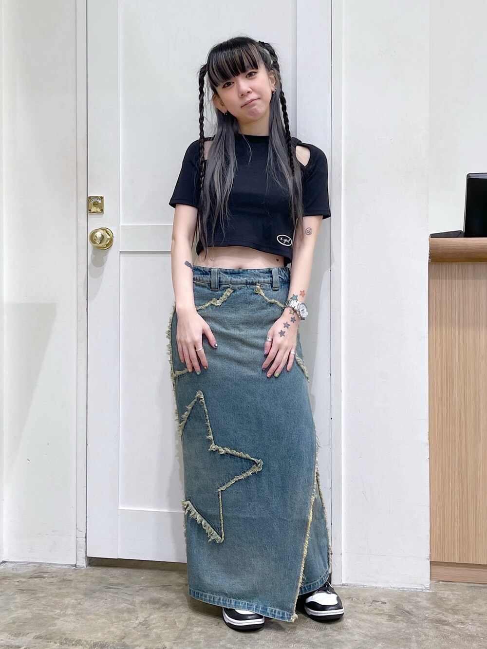 ブラック系のTシャツ/カットソー、ピンク系のショルダーバッグ、ブルー系のデニムスカートを着用したレディースの夏コーディネートの2枚目の写真