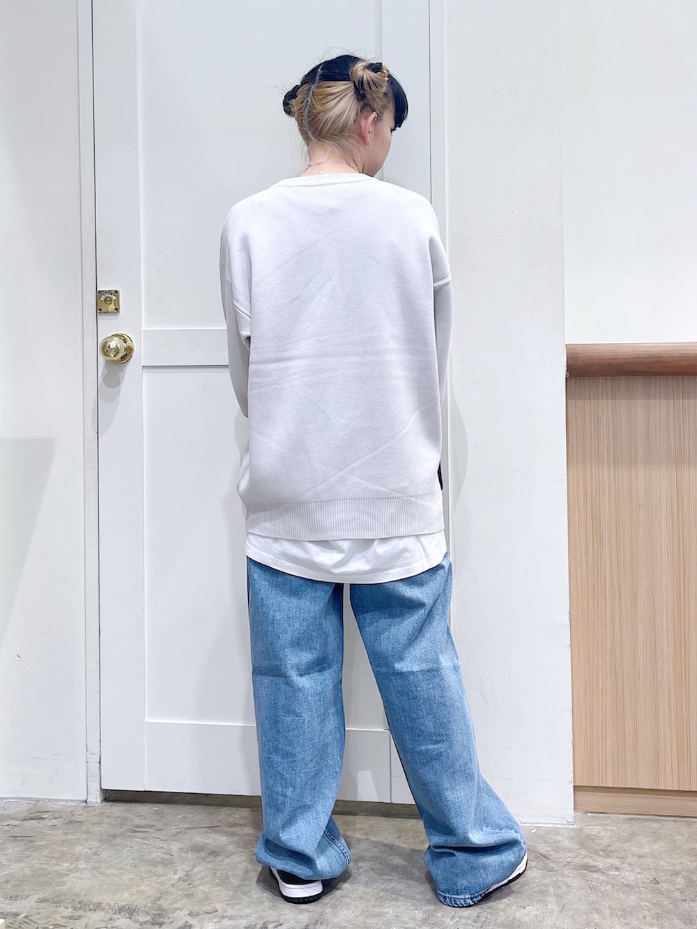 ホワイト系のニット/セーター、ブラック系のショルダーバッグ、ブルー系のデニムパンツを着用したレディースの秋コーディネートの3枚目の写真