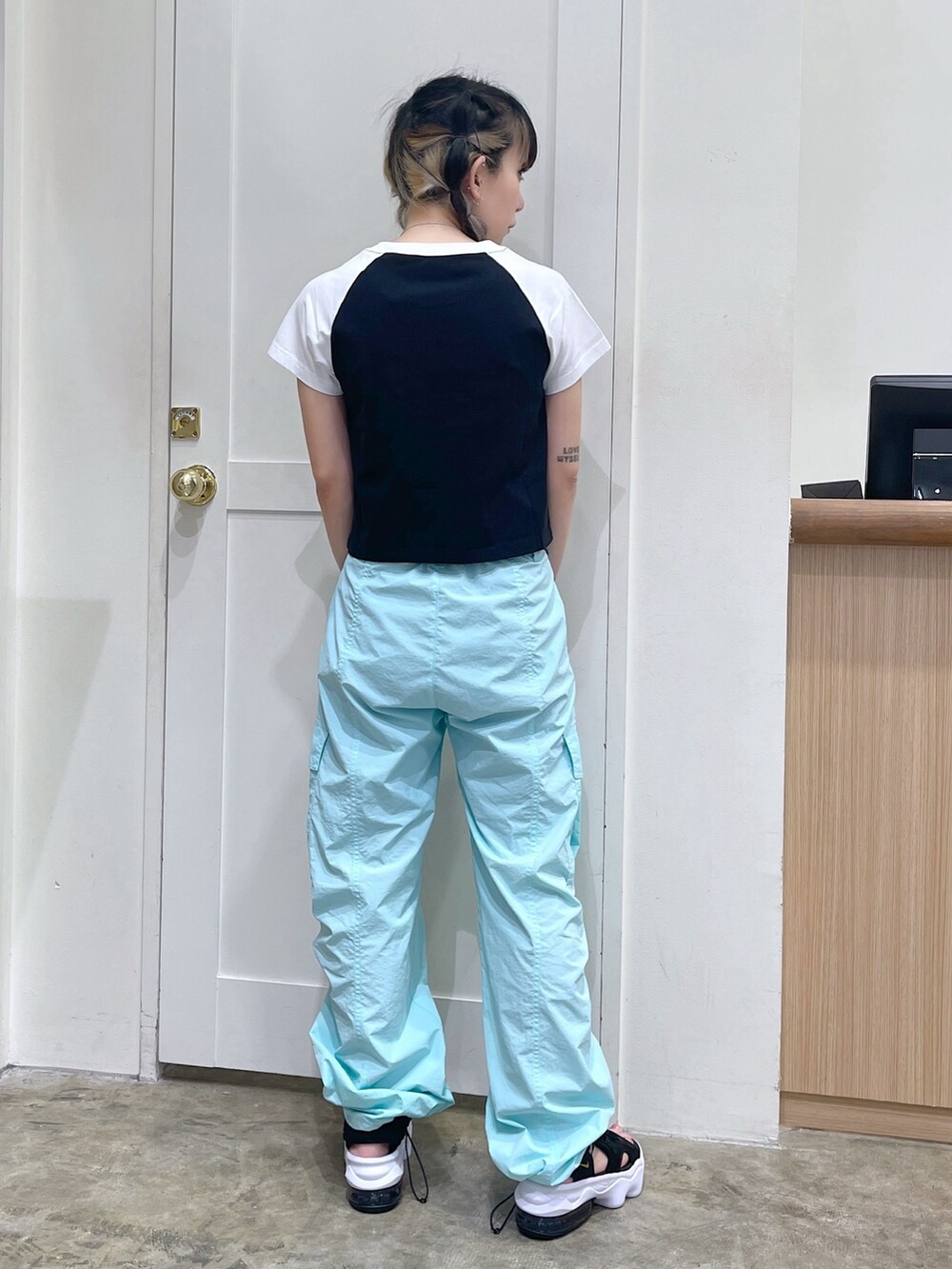 ブラック系のTシャツ/カットソー、グリーン系のカーゴパンツ、ブラック系のサンダルを着用したレディースの夏コーディネートの3枚目の写真