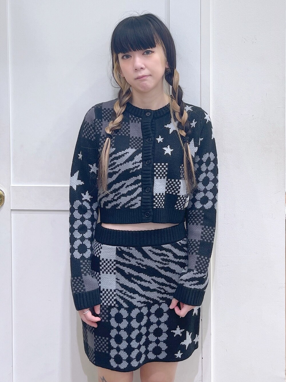 ブラック系のカーディガン/ボレロ、ブラック系のスカート、パープル系のショルダーバッグを着用したレディースの秋コーディネートの4枚目の写真