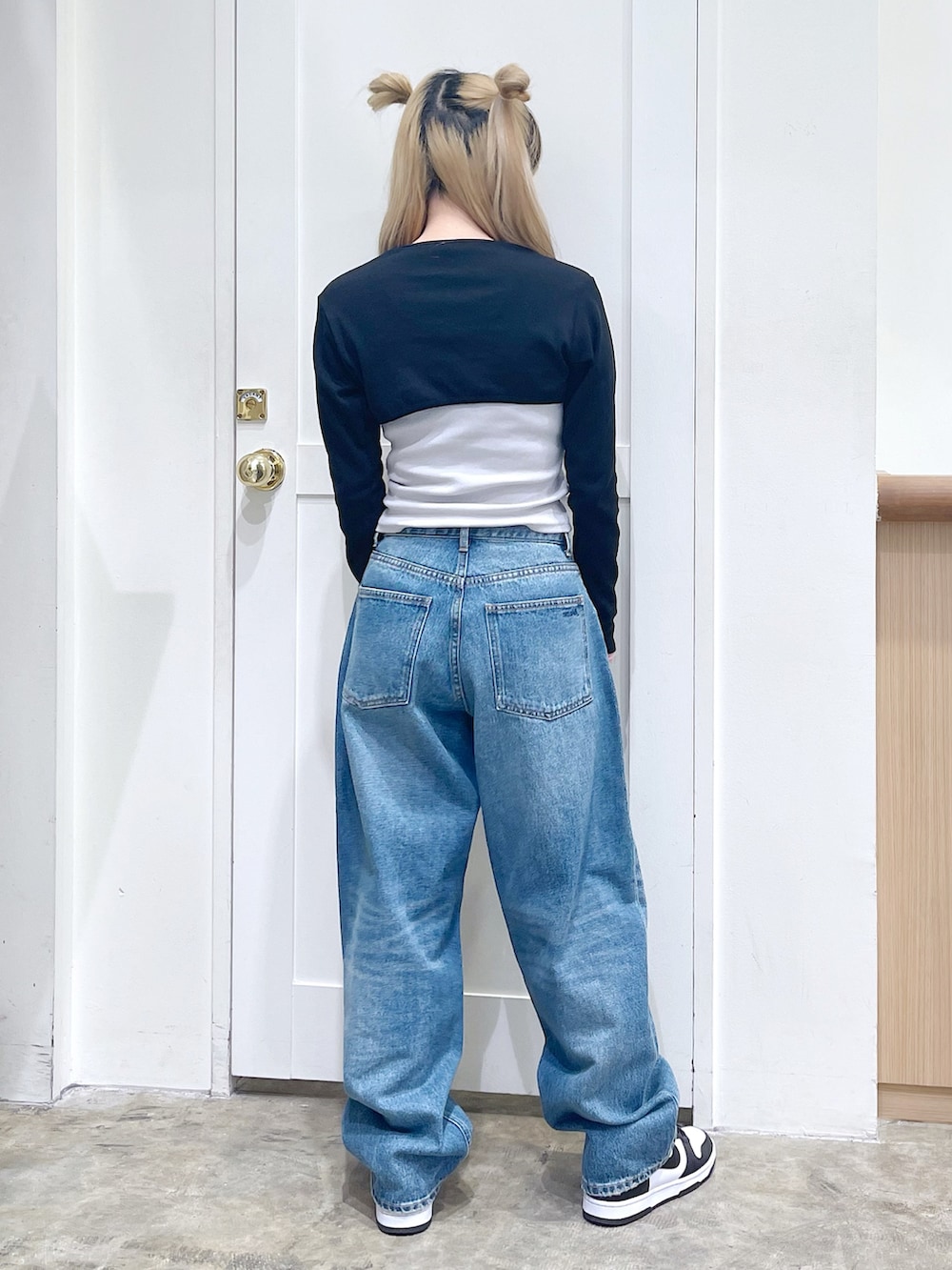 ブラック系のトップス、グレー系のトップス、ブルー系のデニムパンツを着用したレディースの春コーディネートの4枚目の写真