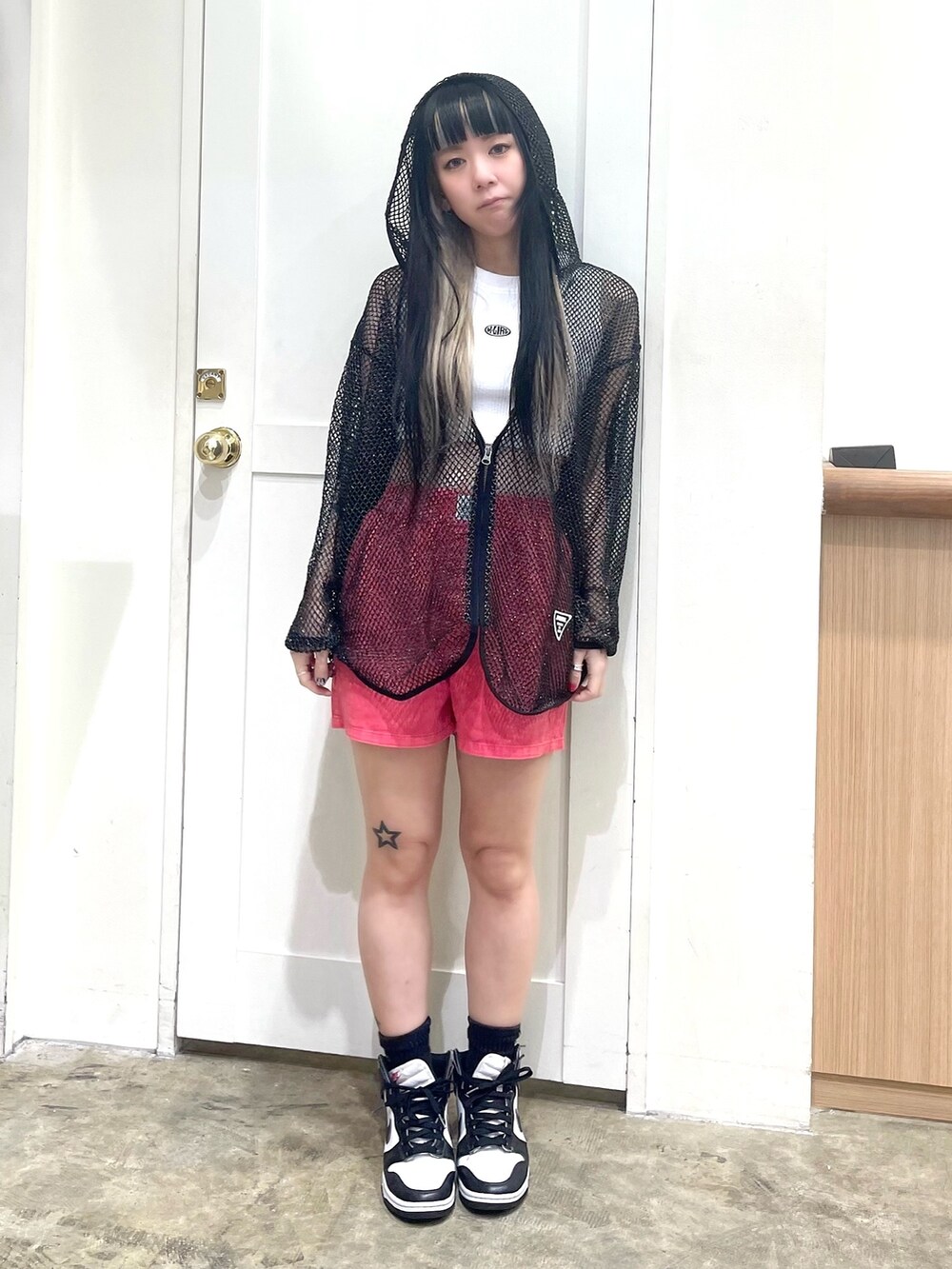 ブラック系のパーカー、ホワイト系のタンクトップ、レッド系のその他パンツを着用したレディースの春コーディネートの2枚目の写真