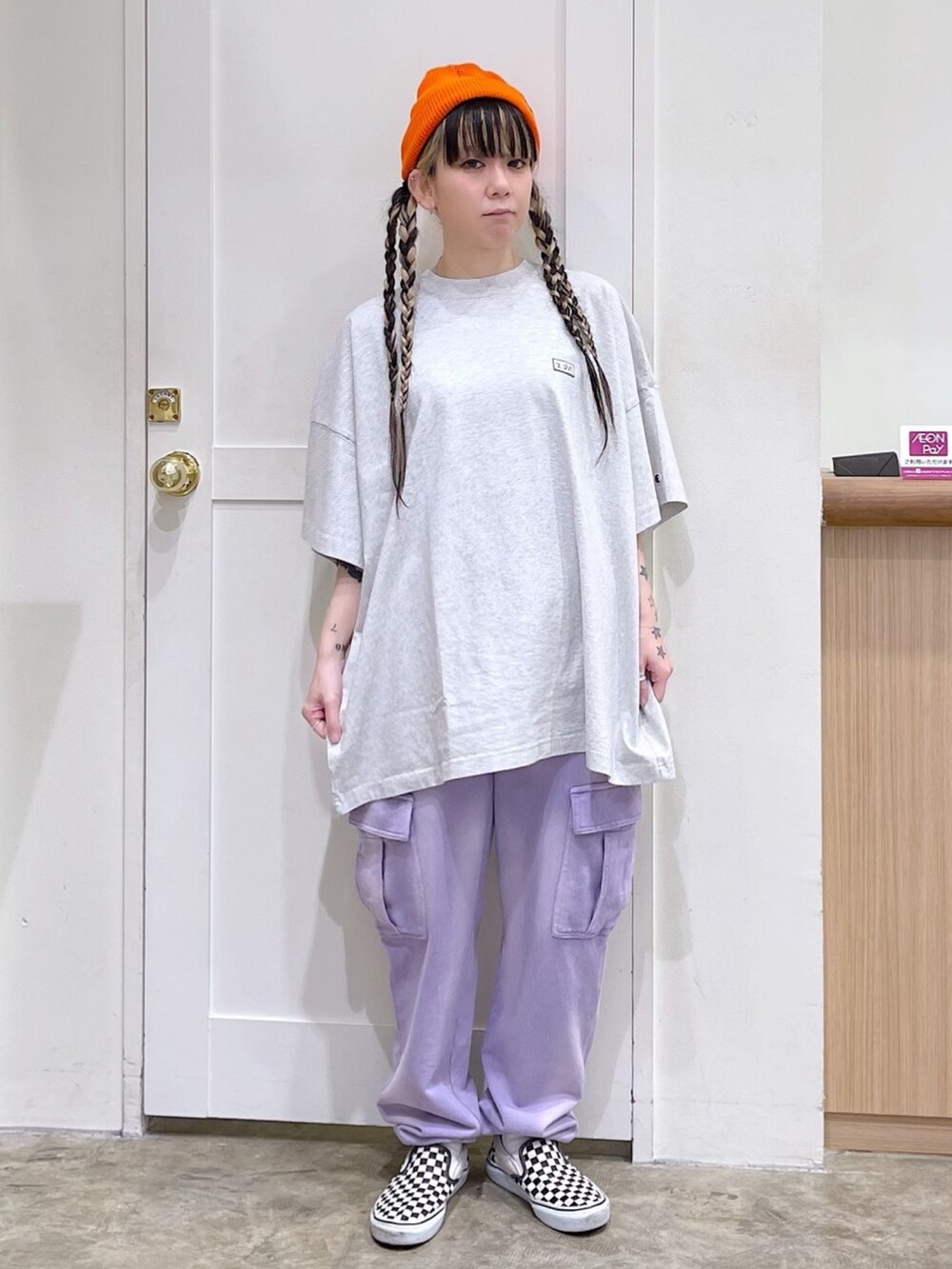 グレー系のワンピース、パープル系のスウェットパンツ、オレンジ系のニットキャップ/ビーニーを着用したレディースの春コーディネートの3枚目の写真