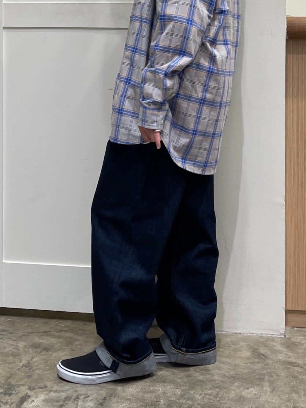 グレー系のシャツ/ブラウス、イエロー系のパーカー、ブルー系のデニムパンツを着用したレディースの秋コーディネートの3枚目の写真