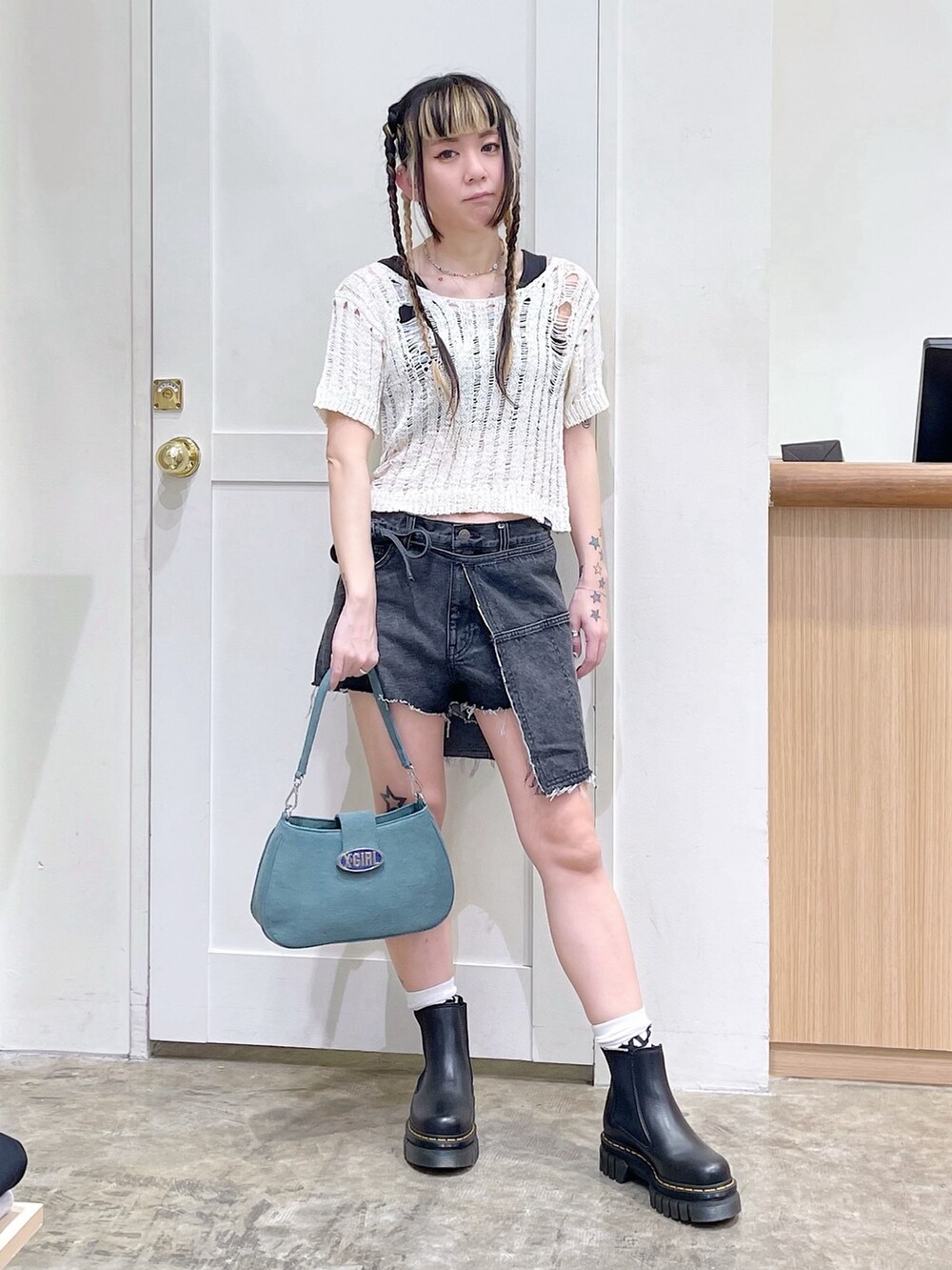 ホワイト系のニット/セーター、ブラック系のタンクトップ、ブルー系のショルダーバッグを着用したレディースの春コーディネートの3枚目の写真