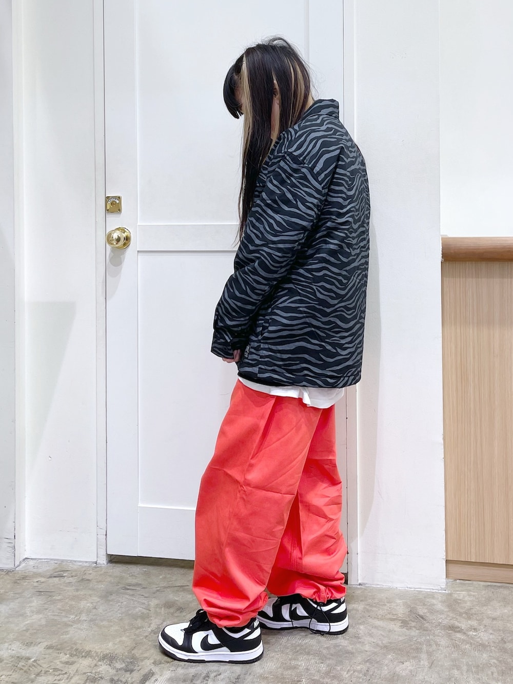 グレー系のその他アウター、ホワイト系のスウェット、オレンジ系のパンツを着用したレディースの秋コーディネートの2枚目の写真