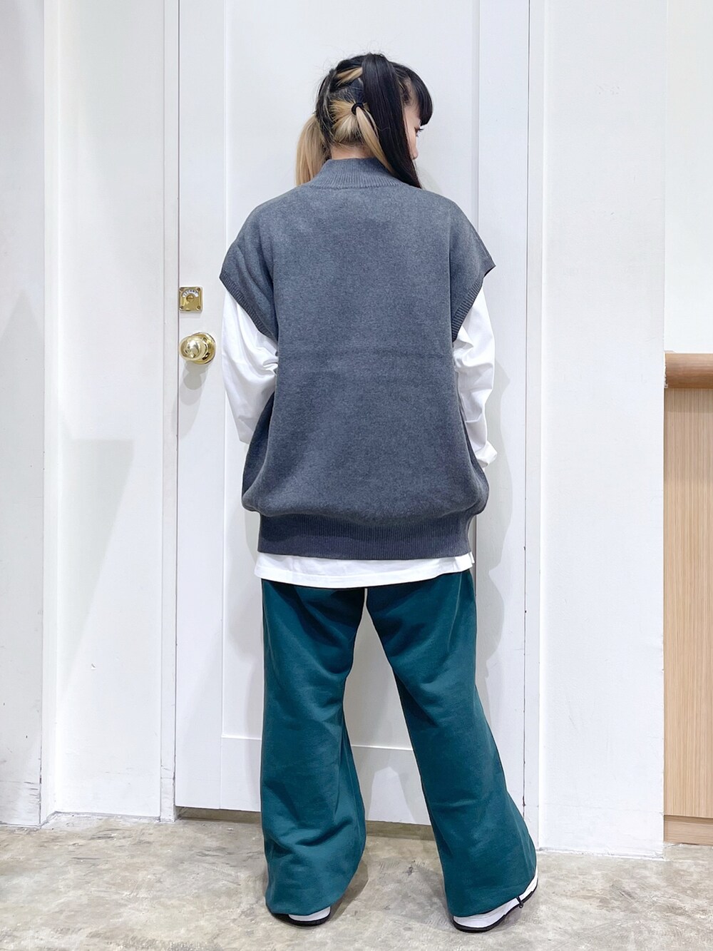 グレー系のベスト、ホワイト系のTシャツ/カットソー、グリーン系のスウェットパンツを着用したレディースの秋コーディネートの5枚目の写真