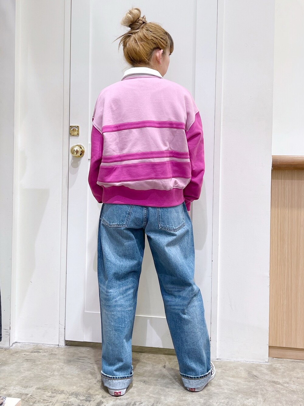 ピンク系のスウェット、ブルー系のデニムパンツ、ホワイト系のトートバッグを着用したレディースの冬コーディネートの5枚目の写真