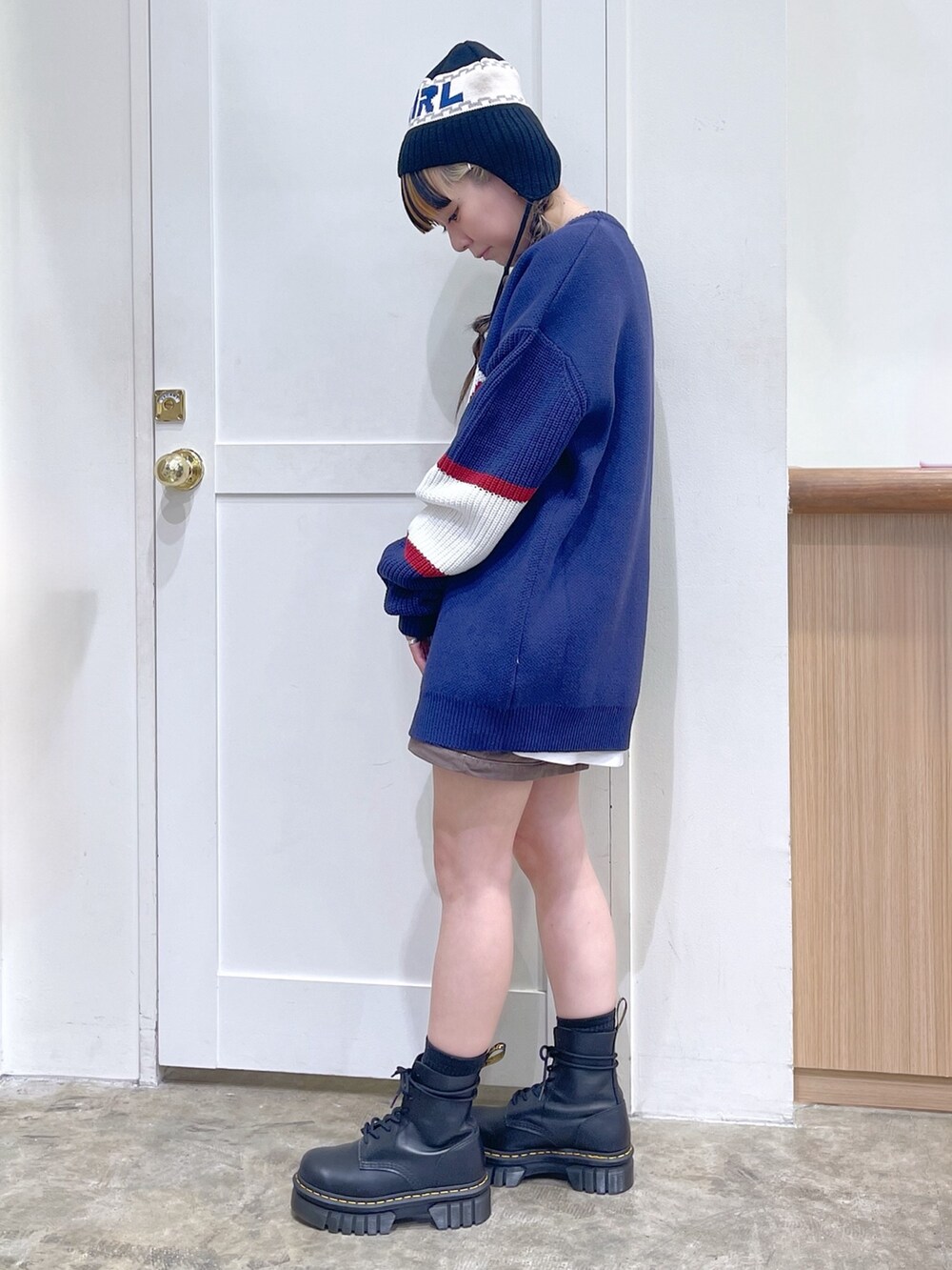 ブルー系のニット/セーター、グリーン系のスカート、ブラック系のブーツを着用したレディースの冬コーディネートの3枚目の写真