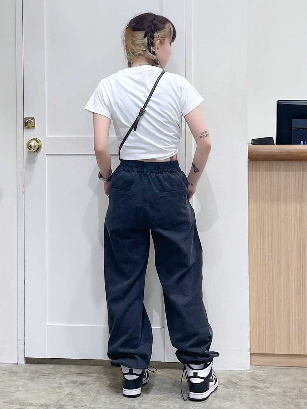 ホワイト系のTシャツ/カットソー、ブラック系のその他パンツ、ゴールド系のコインケースを着用したレディースの夏コーディネートの3枚目の写真