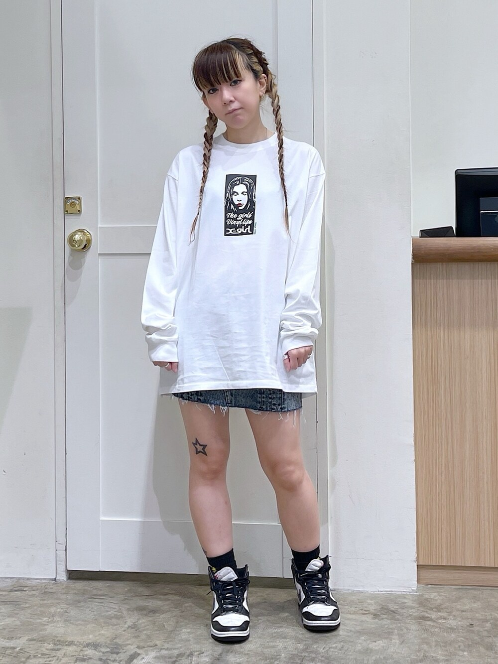 ブラック系のジャージ、ホワイト系のTシャツ/カットソー、ブルー系のデニムスカートを着用したレディースの夏コーディネートの4枚目の写真