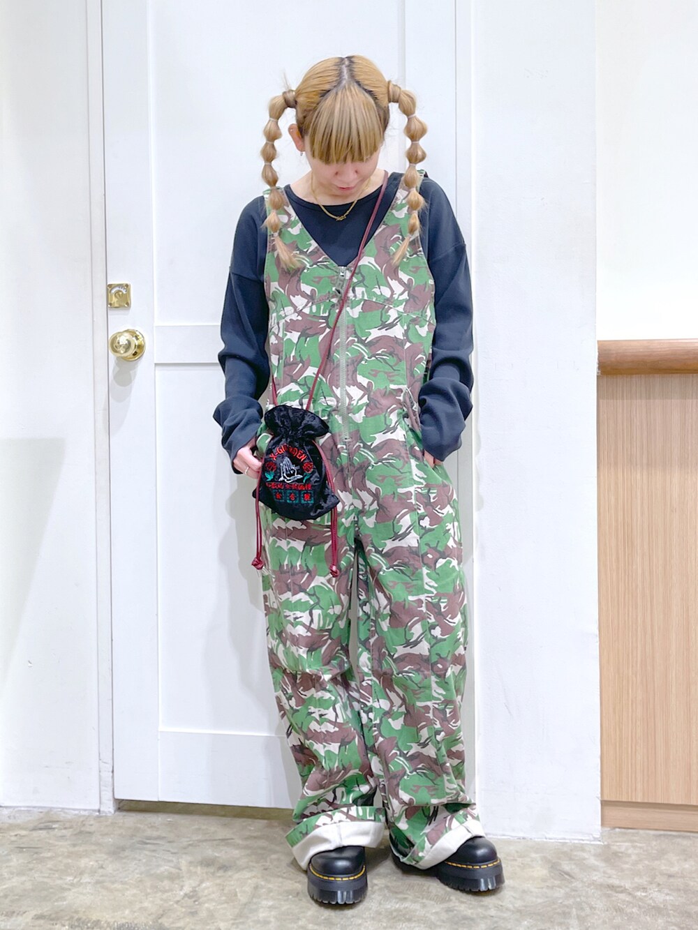 グレー系のTシャツ/カットソー、グリーン系のサロペット/オーバーオール、ブラック系のショルダーバッグを着用したレディースの秋コーディネートの2枚目の写真