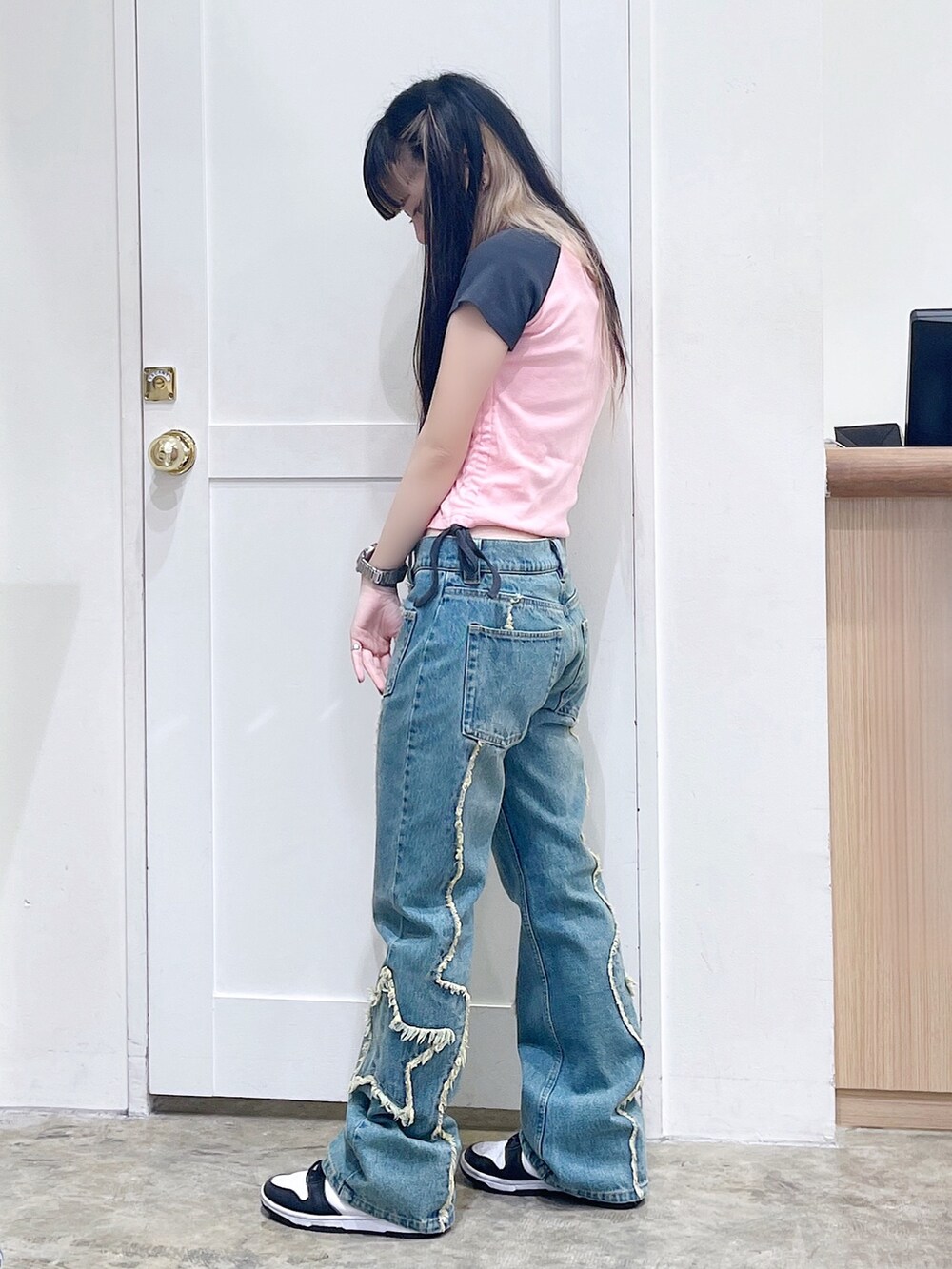 ピンク系のTシャツ/カットソー、ブルー系のデニムパンツ、ブラック系のハンドバッグを着用したレディースの夏コーディネートの3枚目の写真