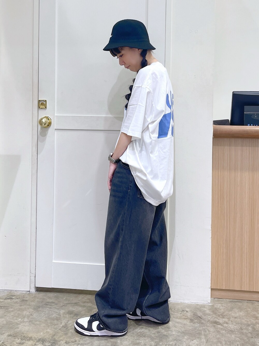 ホワイト系のTシャツ/カットソー、ブラック系のデニムパンツ、ブラック系のハットを着用したレディースの夏コーディネートの3枚目の写真