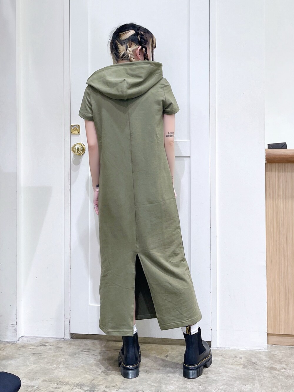 グレー系のトートバッグ、グリーン系のワンピース、ブラック系のブーツを着用したレディースの春コーディネートの5枚目の写真