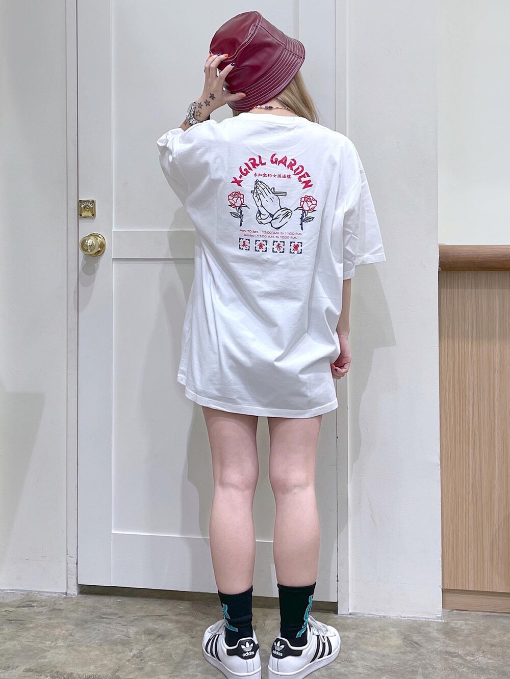 ホワイト系のTシャツ/カットソー、ブルー系のデニムパンツ、レッド系のハットを着用したレディースの夏コーディネートの5枚目の写真