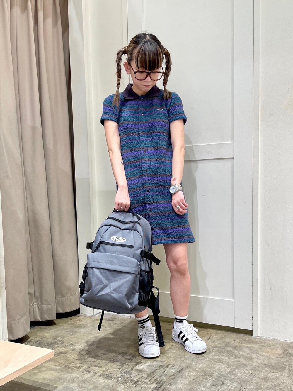 グリーン系のワンピース、グレー系のバックパック/リュックを着用したレディースの春コーディネートの2枚目の写真