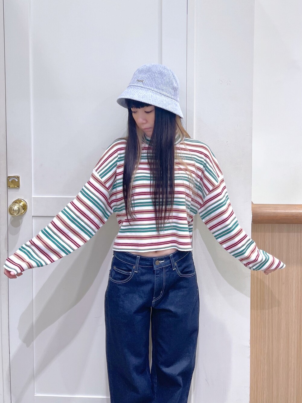 ホワイト系のカーディガン/ボレロ、ホワイト系のニット/セーター、ブルー系のデニムパンツを着用したレディースの秋コーディネートの5枚目の写真