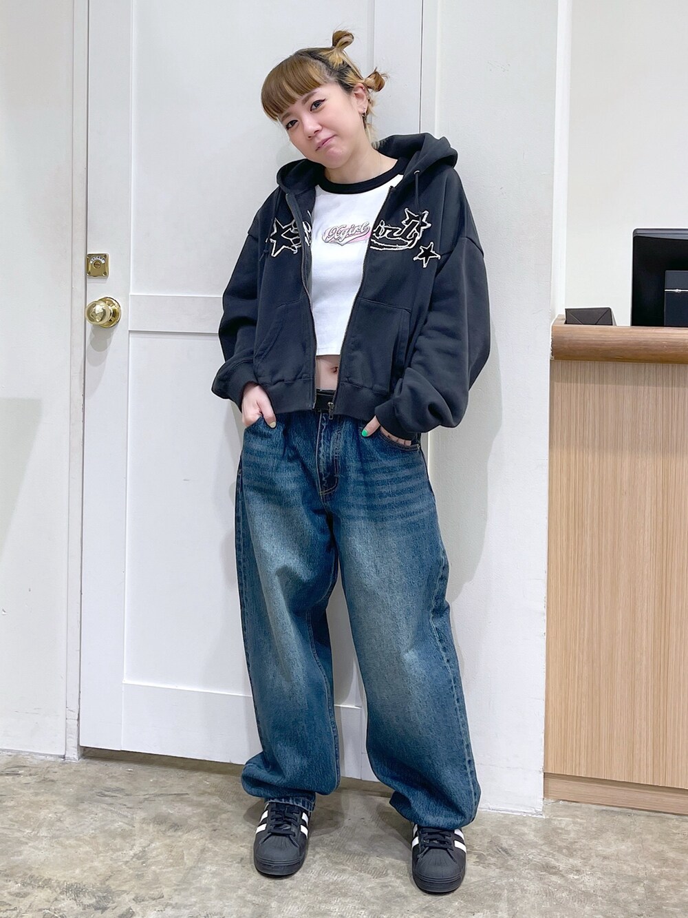 ブラック系のパーカー、ホワイト系のTシャツ/カットソー、ブルー系のデニムパンツを着用したレディースの春コーディネートの2枚目の写真