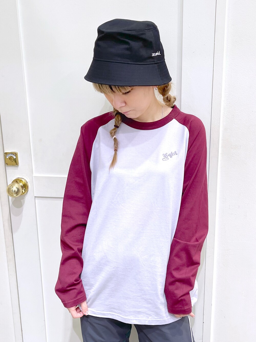 レッド系のTシャツ/カットソー、グリーン系のその他パンツ、ブラック系のハットを着用したレディースの冬コーディネートの2枚目の写真