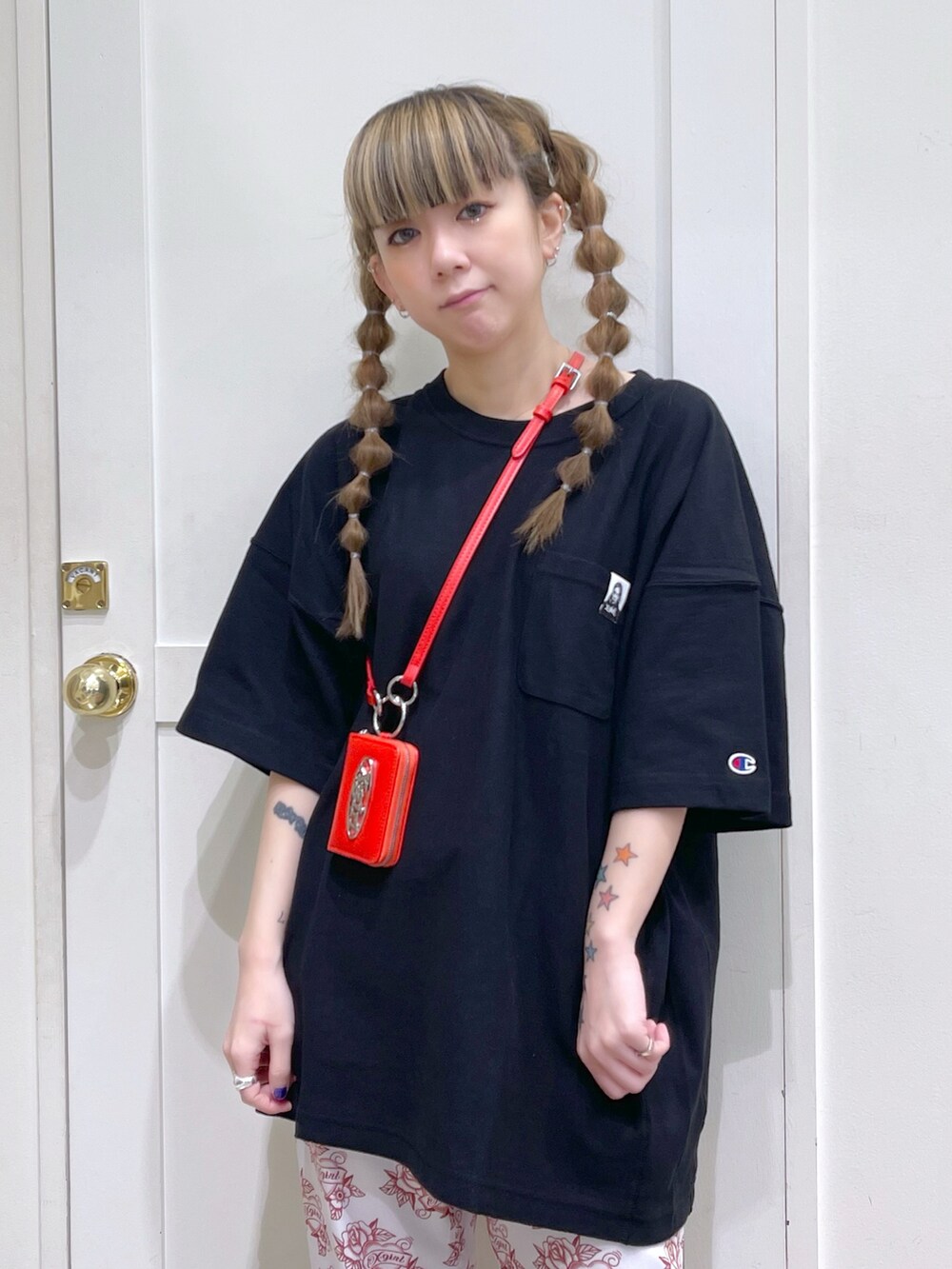 ブラック系のTシャツ/カットソー、ホワイト系のその他パンツ、レッド系のコインケースを着用したレディースの春コーディネートの4枚目の写真