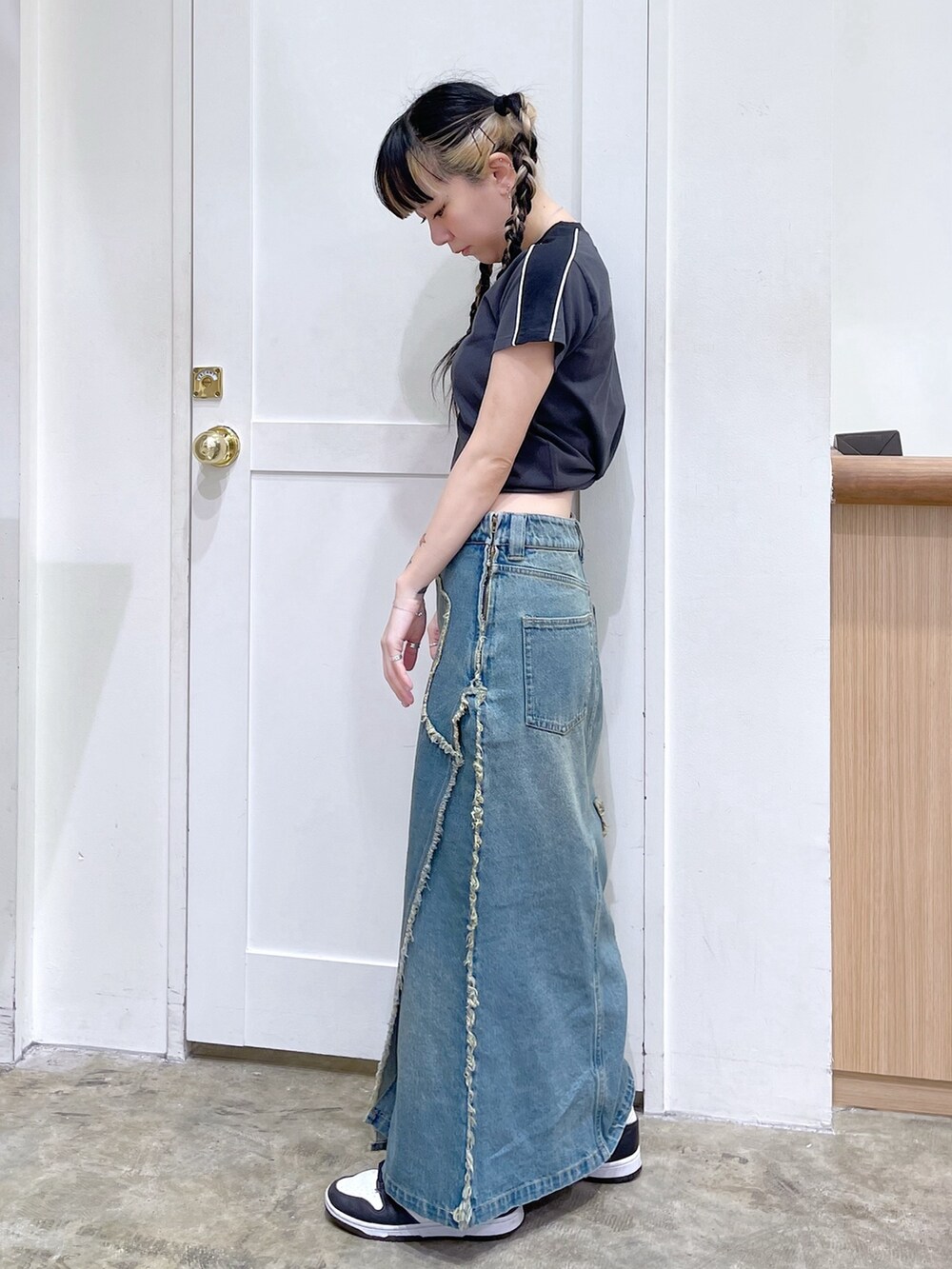 グレー系のTシャツ/カットソー、ブルー系のデニムスカート、ピンク系のショルダーバッグを着用したレディースの春コーディネートの4枚目の写真