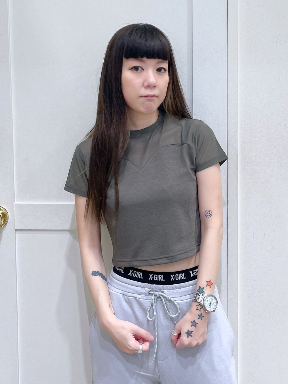 グリーン系のTシャツ/カットソー、グレー系のスウェットパンツ、ブラウン系のキャップを着用したレディースの夏コーディネートの5枚目の写真
