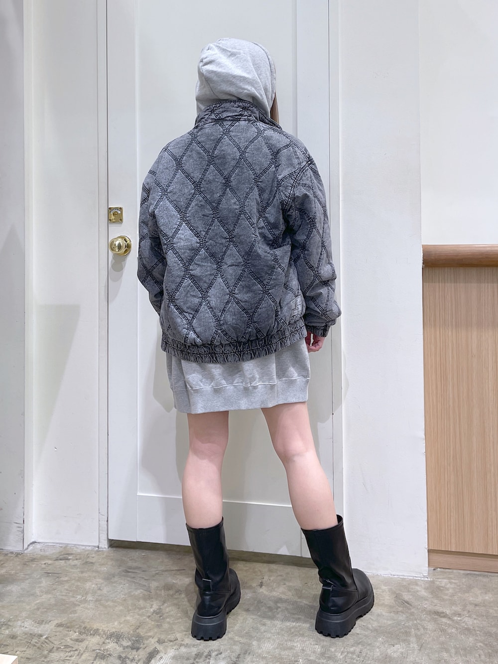 グレー系のパーカー、ブラック系のその他アウター、ホワイト系のショルダーバッグを着用したレディースの冬コーディネートの3枚目の写真