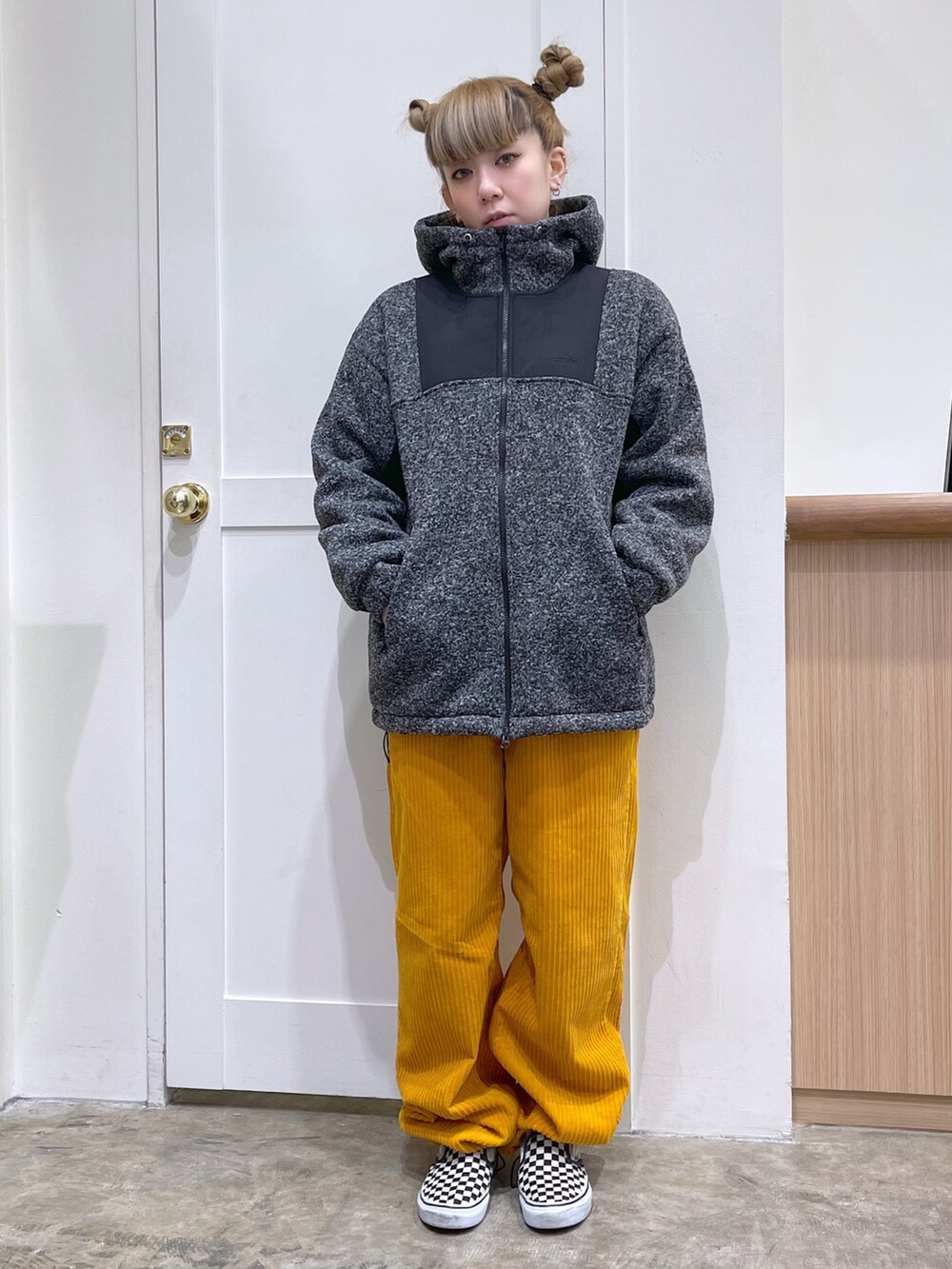 ブラック系のブルゾン、グレー系のTシャツ/カットソー、イエロー系のその他パンツを着用したレディースの冬コーディネートの2枚目の写真