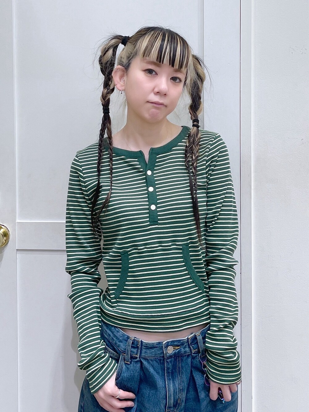 グリーン系のTシャツ/カットソー、ブルー系のデニムパンツ、ブラック系のショルダーバッグを着用したレディースの冬コーディネートの4枚目の写真