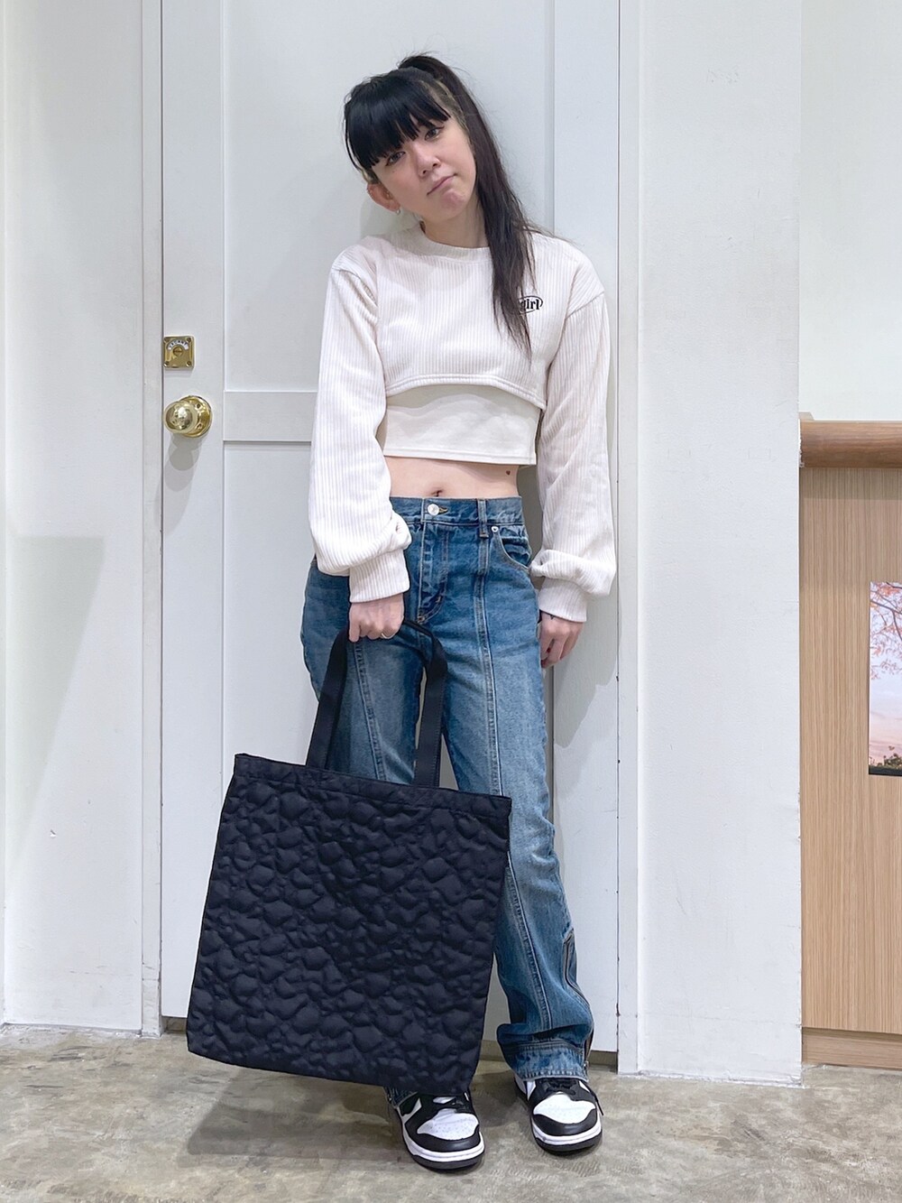 ホワイト系のTシャツ/カットソー、ブルー系のデニムパンツ、ブラック系のトートバッグを着用したレディースの秋コーディネートの3枚目の写真