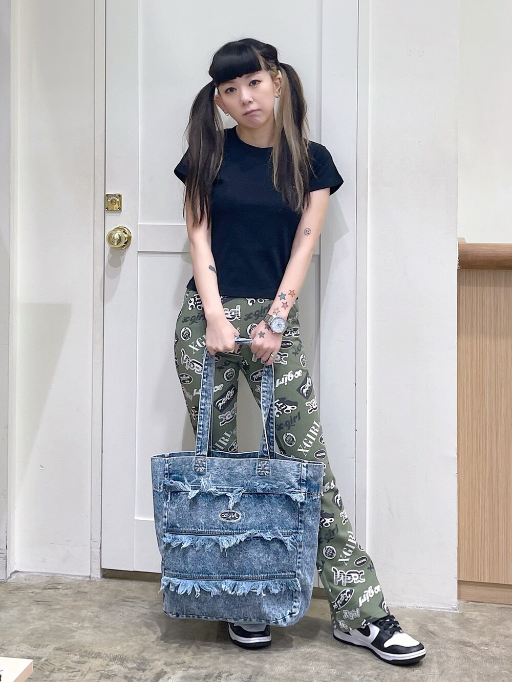 ブラック系のTシャツ/カットソー、グリーン系のその他パンツ、ブルー系のトートバッグを着用したレディースの春コーディネートの3枚目の写真