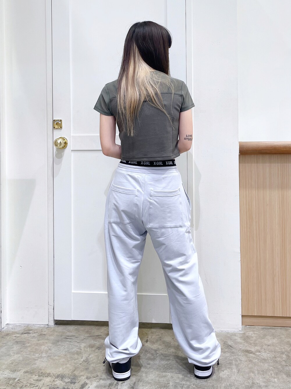 グリーン系のTシャツ/カットソー、グレー系のスウェットパンツ、ブラウン系のキャップを着用したレディースの夏コーディネートの4枚目の写真