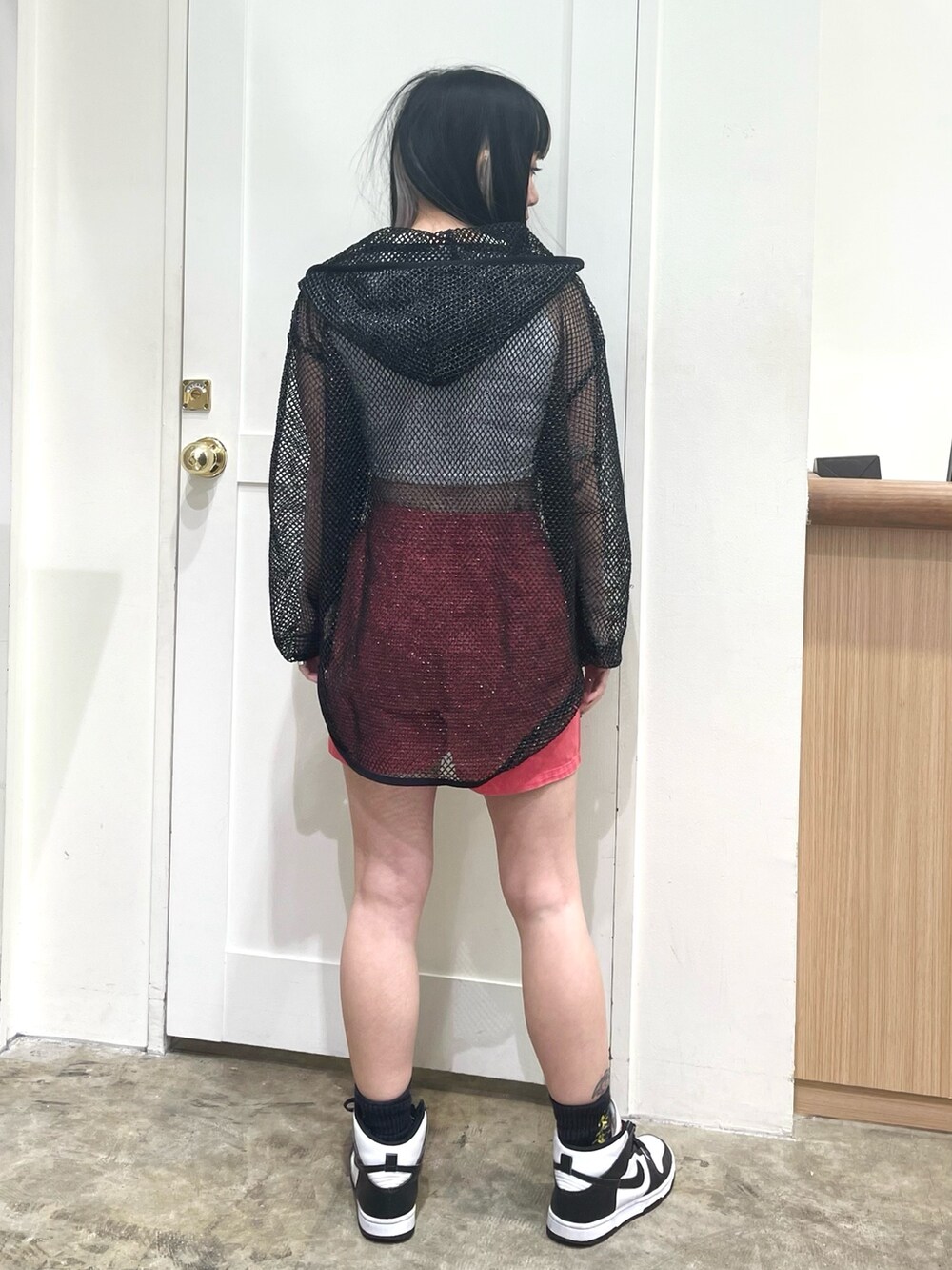 ブラック系のパーカー、ホワイト系のタンクトップ、レッド系のその他パンツを着用したレディースの春コーディネートの4枚目の写真