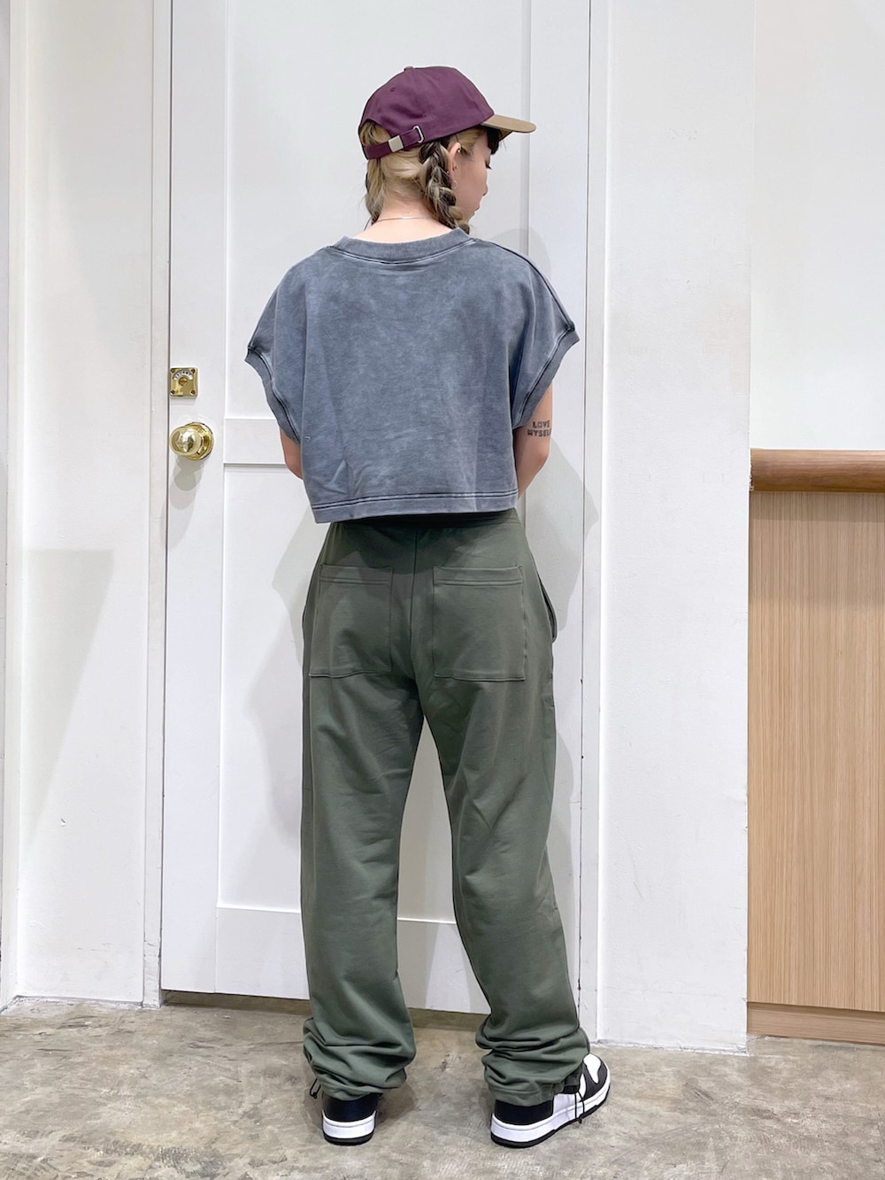 グレー系のタンクトップ、ブラウン系のキャミソール、グリーン系のスウェットパンツを着用したレディースの夏コーディネートの4枚目の写真