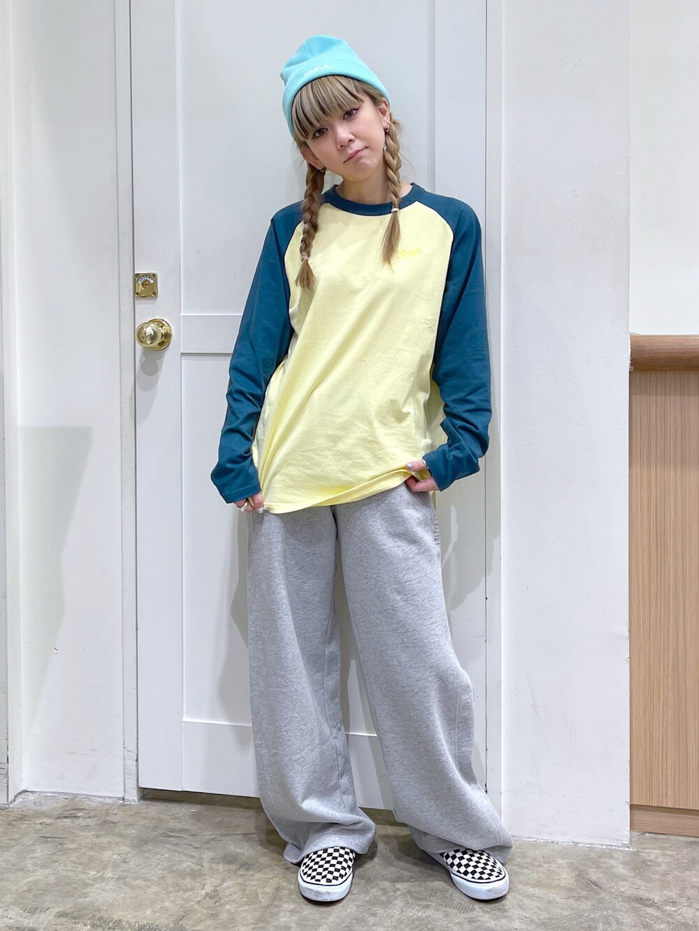 グリーン系のTシャツ/カットソー、グレー系のスウェットパンツ、グリーン系のニットキャップ/ビーニーを着用したレディースの冬コーディネートの2枚目の写真