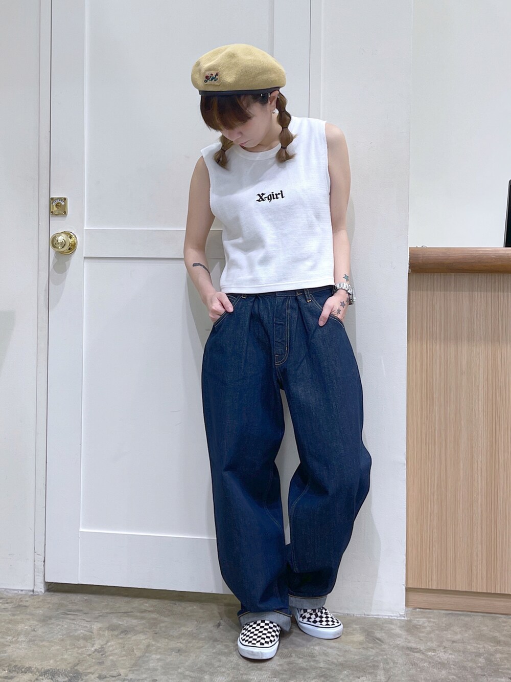 ホワイト系のタンクトップ、ブルー系のデニムパンツ、ベージュ系のハンチング/ベレー帽を着用したレディースの夏コーディネートの2枚目の写真