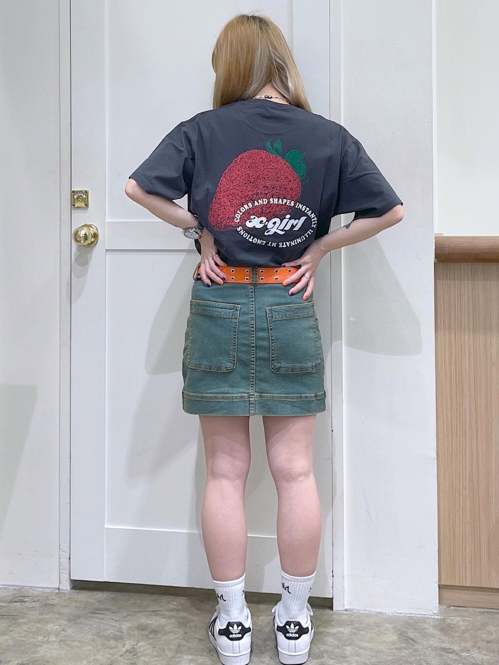 グレー系のTシャツ/カットソー、ブルー系のスカート、オレンジ系のベルトを着用したレディースの夏コーディネートの3枚目の写真