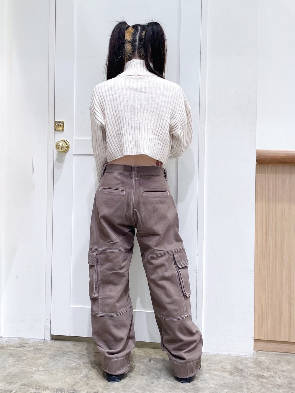 ベージュ系のパーカー、ホワイト系のニット/セーター、グリーン系のカーゴパンツを着用したレディースの秋コーディネートの6枚目の写真