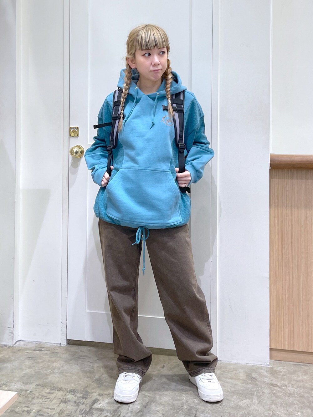 グリーン系のパーカー、ブラウン系のデニムパンツ、グレー系のバックパック/リュックを着用したレディースの冬コーディネートの2枚目の写真