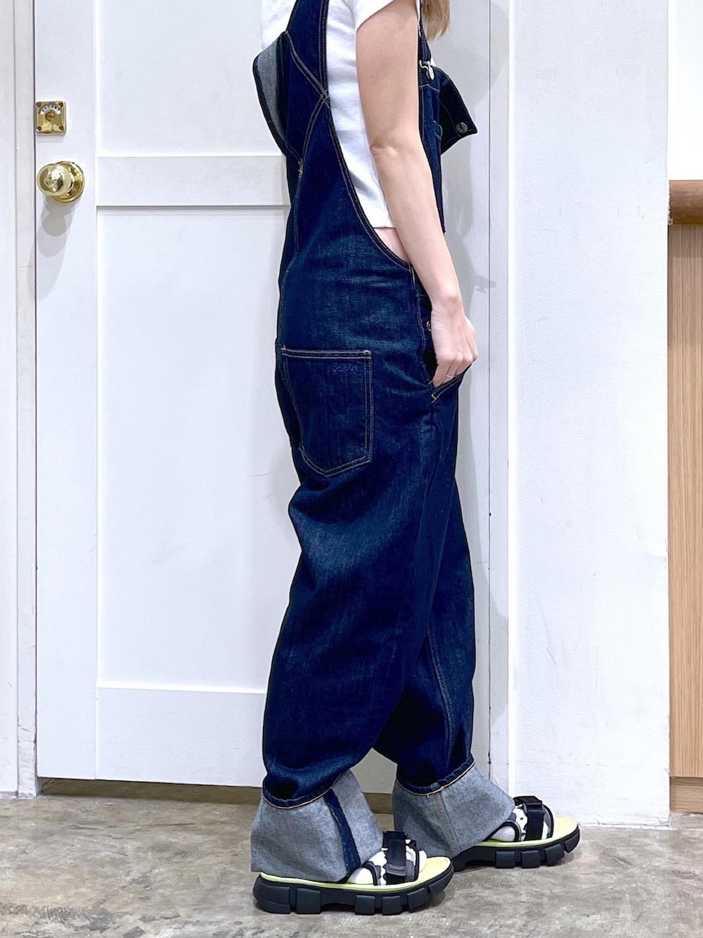 ホワイト系のTシャツ/カットソー、ブルー系のサロペット/オーバーオール、ブラック系のサンダルを着用したレディースの夏コーディネートの3枚目の写真