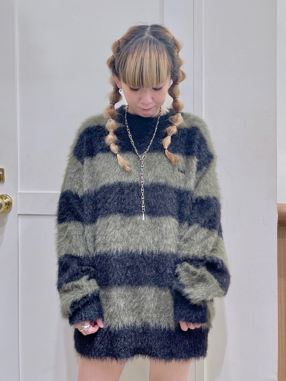 ブルー系のデニムジャケット、ブラック系のニット/セーター、ホワイト系のブーツを着用したレディースの冬コーディネートの5枚目の写真